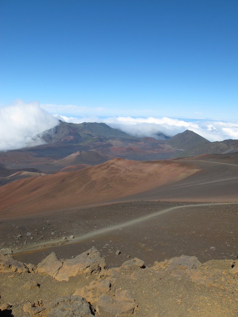 View from Haleakala (highest mountain on Maui, Hawaii) onto a moon-like volcanic landscape. However, the clouds below us and the blue sky make clear, it's not the moon (by Ronny Errmann).